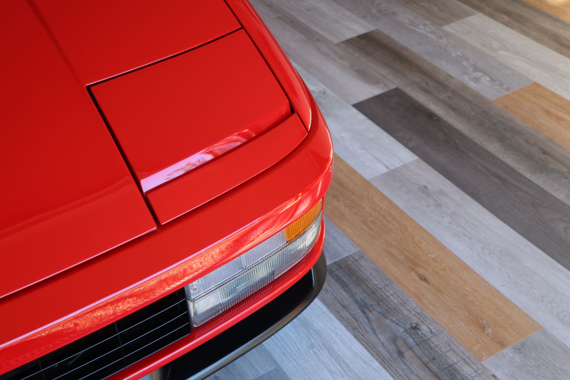 Red Ferrari in storage with laminate flooring