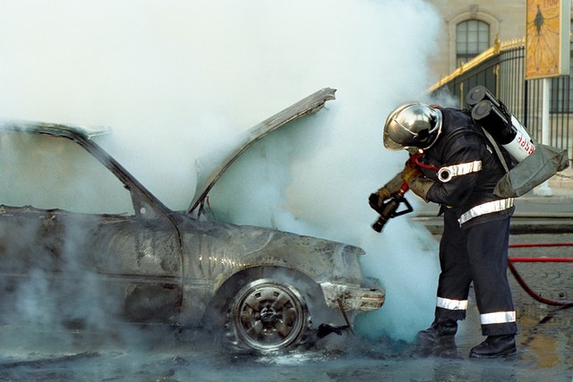 Firefighter putting out car fire