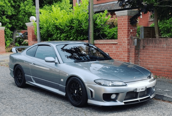 Silver Nissan S15 parked by wall